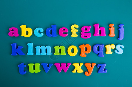 绿色背景上的彩色字母磁字母图片