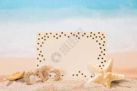 沙子中的空白卡心和海星背景图片