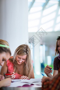 一群大学生或大学生在课间休息聊天比较笔记玩得开心图片