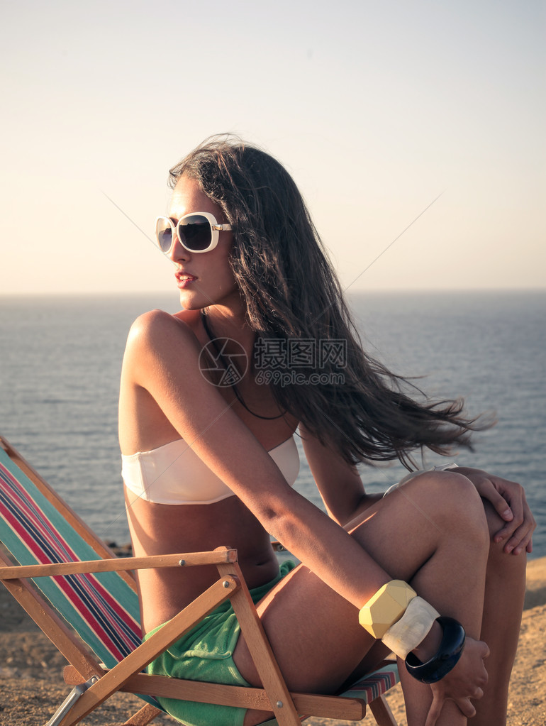 坐在海边沙滩上的女人图片