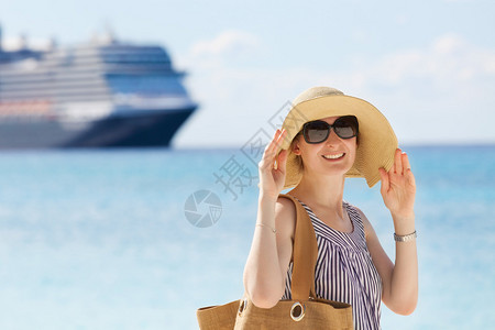 年轻的微笑的年轻女士享受海滩度假与游轮图片