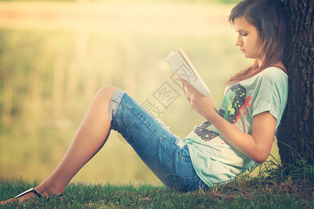 在公园里看书的女孩背景图片