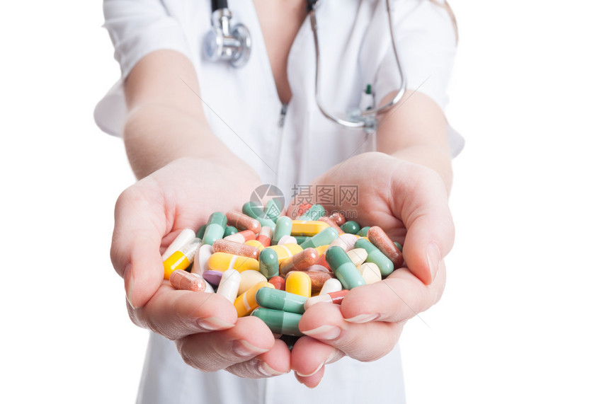 女医生手握着白色背景的多种彩色药丸图片