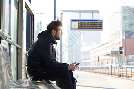 一位坐在火车站板凳上微笑的年图片