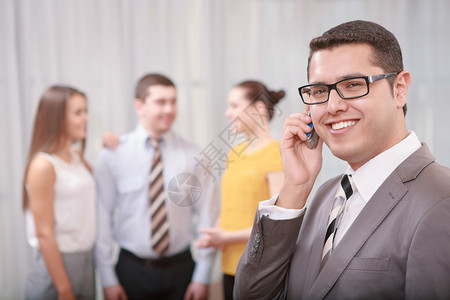 自信英俊的商人在电话里面带微笑地交谈图片