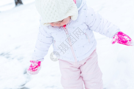 可爱的蹒跚学步的孩子在新雪中玩耍图片