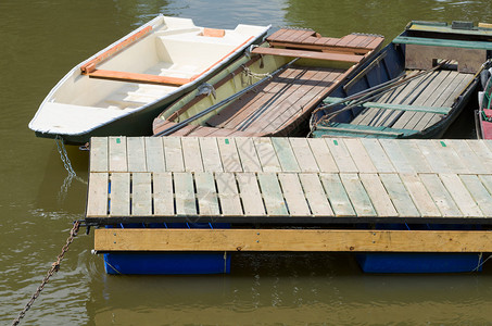 用铁链停泊在河上的浮动码头的小船图片