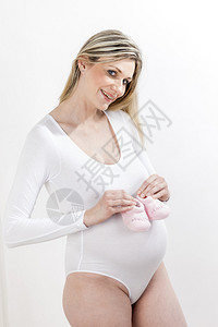 为婴儿穿鞋站立的孕妇肖像图片