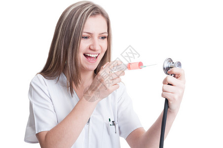 带着针筒和听诊器的快乐女医护人员在白色背景上持有注图片