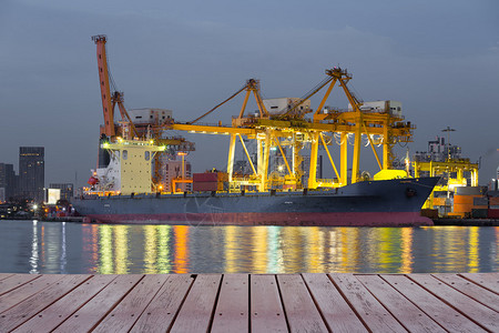 在港口与起重机一起工作的货船在河面反图片