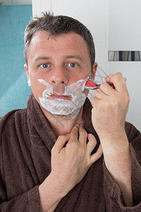 男人用剃刀片刮胡子图片
