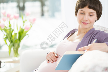 孕妇坐在沙发上看书图片