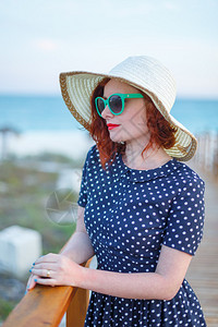 红发女孩穿着海边的帽子和墨镜图片