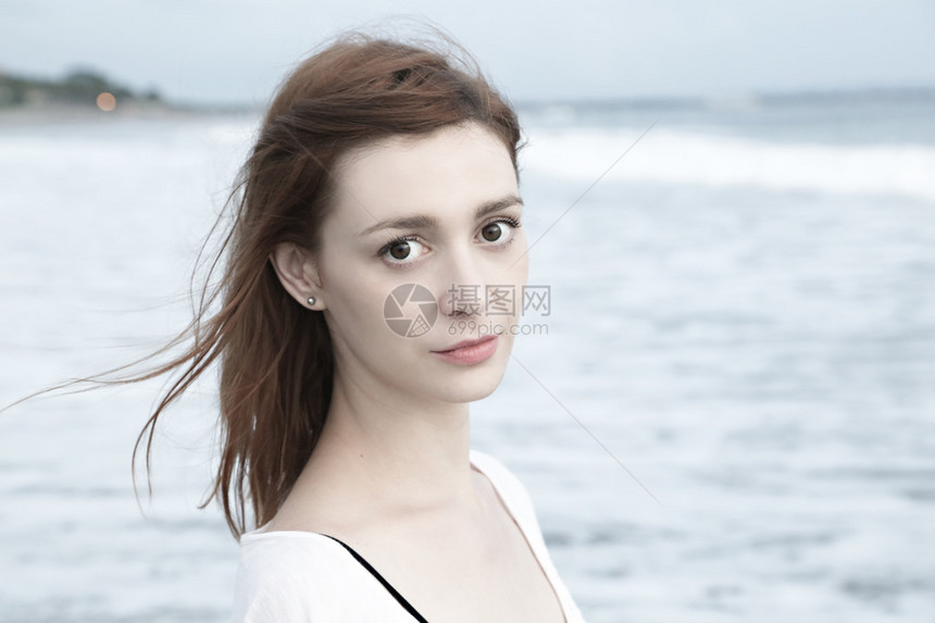 海滩上漂亮女孩的近身肖像浅色调图片