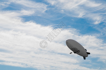 飞艇在蓝色多云的天空中飞行图片