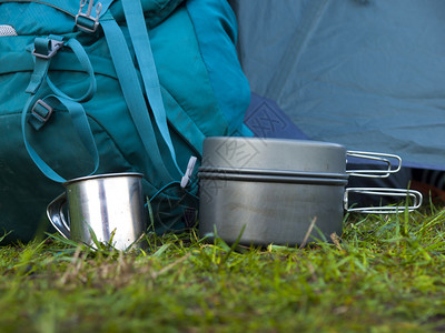 一个金属锅和一个杯子站在草地上在背包高清图片
