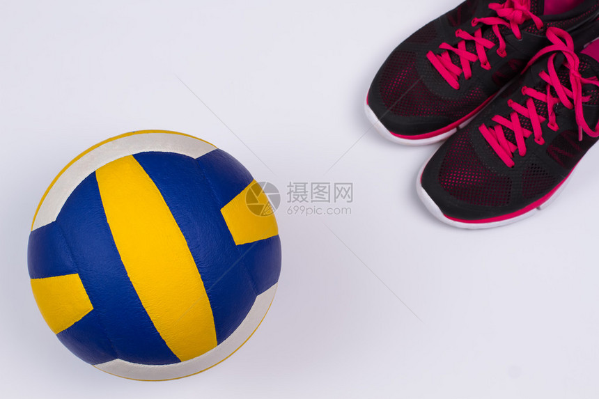女跑鞋和彩色排球在白色背景上图片