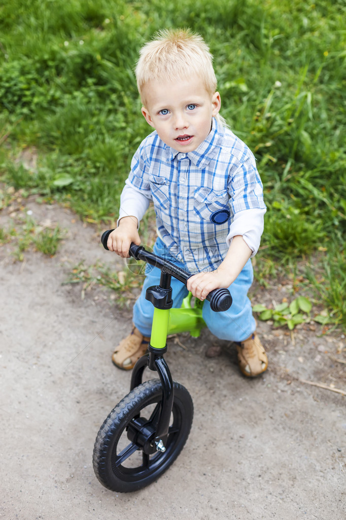 快乐的小男孩在街上骑着图片