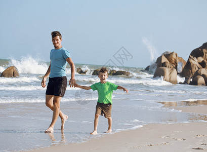 父亲和儿子一起走在海边图片