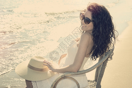 坐在沙滩的时装女孩温暖图片