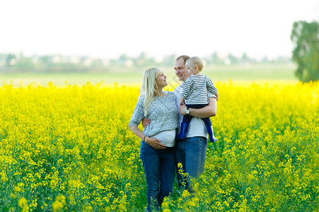 孕妈爸和孩子在油菜花田图片