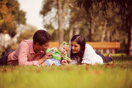 父母带着女婴坐在公园的草地上图片