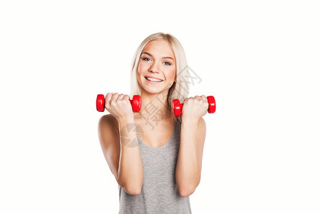 美丽的金发女郎在健身运动中用哑铃图片