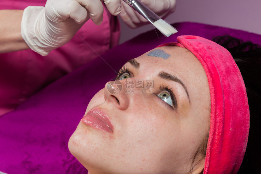 化妆师在模特的脸上戴活化面罩在温泉图片