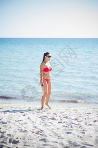 夏天在沙滩的美丽的年轻女士图片