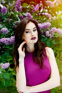 美丽的女人在美丽的淡紫色花朵背景图片