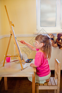 小女孩在画布上画水彩画站图片