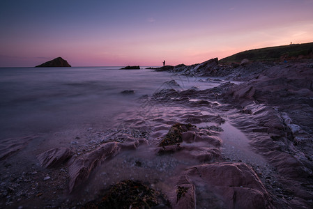 黄昏时清静的海景在岩石海滩图片