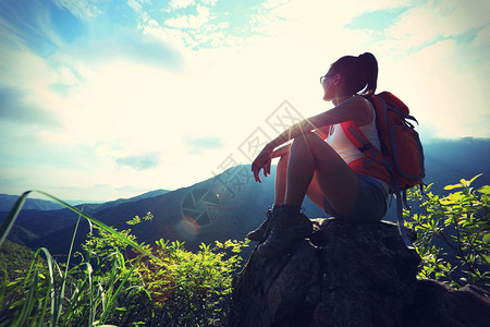 山峰上欣赏风景的女背包客图片