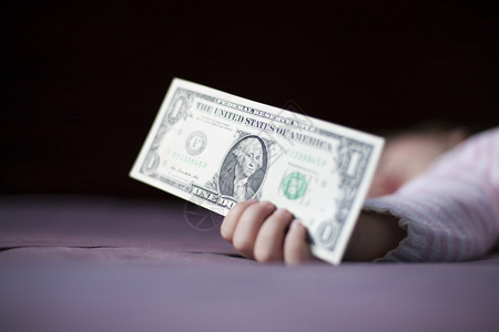 一美元钞票在金色的caucasian婴儿手中十九个月19岁图片