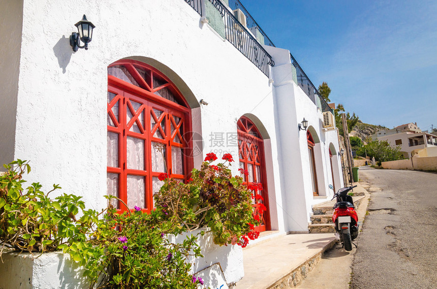 希腊典型希腊房屋前的红色摩托车红色门框图片