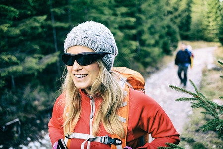 男人和女人的徒步旅行者背着包走在绿色森林山脉的小路上图片