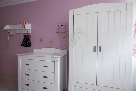 白色和玫瑰色婴儿房的内部图片