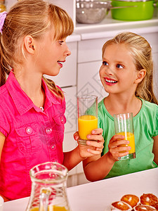 在厨房享用橙汁的快乐儿童早餐图片