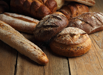 木制背景上的面包分类新鲜烘焙用不同的谷物什锦特图片