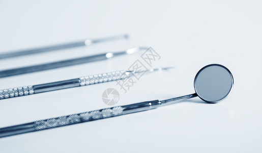 蓝色背景下的牙科工具和设备一套用于牙齿科护理的金属图片