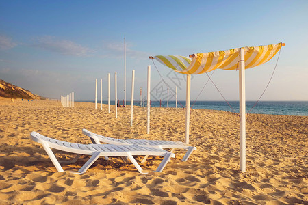 在沙滩上有金沙的滩上带遮太阳和甲板椅的多姿高清图片