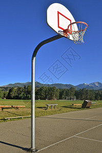 一个户外篮球场以雄伟的山脉为背景图片