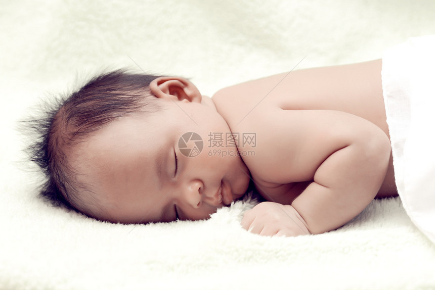 安静的婴儿躺在床上睡在白色床单上图片