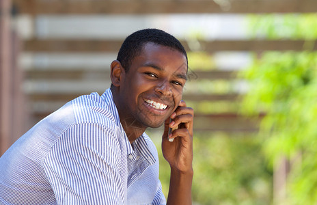 在外边使用手机的笑着的黑人男图片