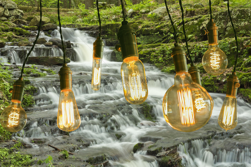 古色香的爱迪生风格的灯泡悬挂在迷雾缭绕的瀑布上方图片