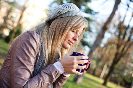 年轻女子在公园喝茶图片