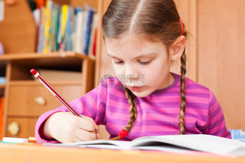 学龄前儿童在她的速写本中绘制图像图片