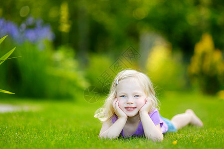 可爱的小女孩躺在草地上在阳图片