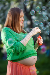 孕妇在户外享受着吹泡的时光图片
