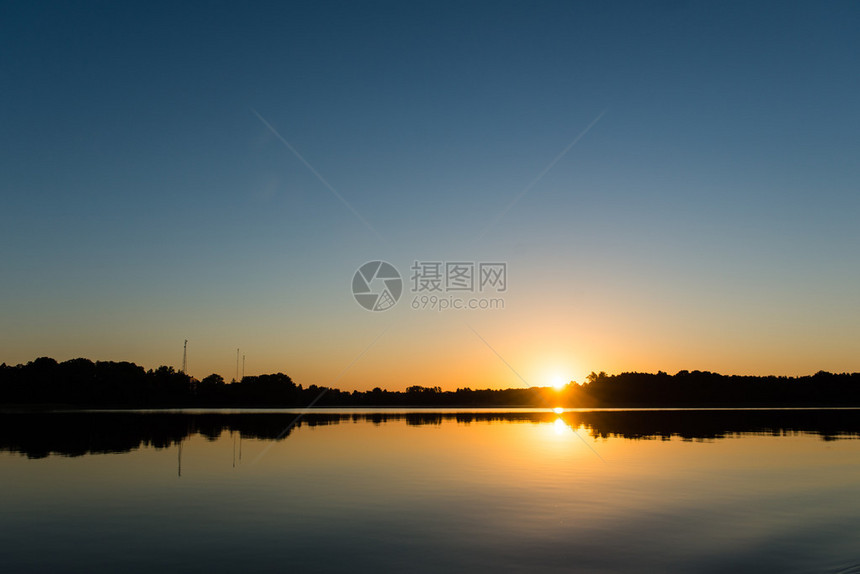 森林和岛屿对平静的湖泊水与森林和岛图片